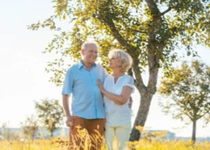 Senior couple walking side by side in a sunny public park