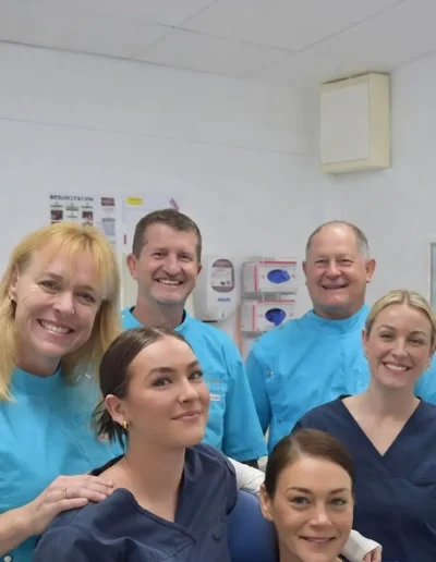 Custom Denture Clinic dental team gathered in a treatment room.